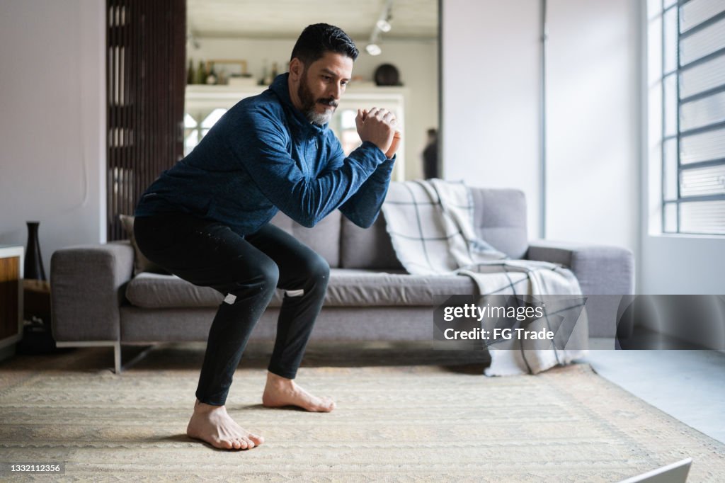 Reifer Mann hockt zu Hause