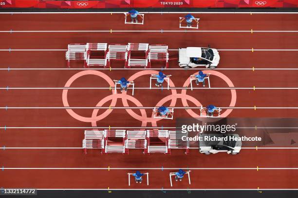Volunteers remove the hurdles following round one of the Men's 110m Hurdles heats one of the Men's 110m Hurdles heats on day eleven of the Tokyo 2020...