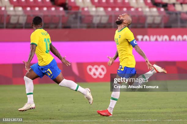 Malcom and Dani Alves of Team Brazil celebrate their side's victory in the penalty shoot out after the Men's Football Semi-final match between Mexico...