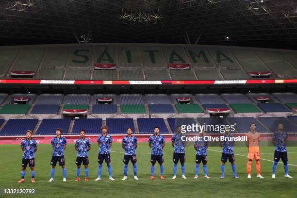 Players of Team Japan stand for the national anthem prior to the Men's Football Semi-final match between Japan and Spain on day eleven of the Tokyo...