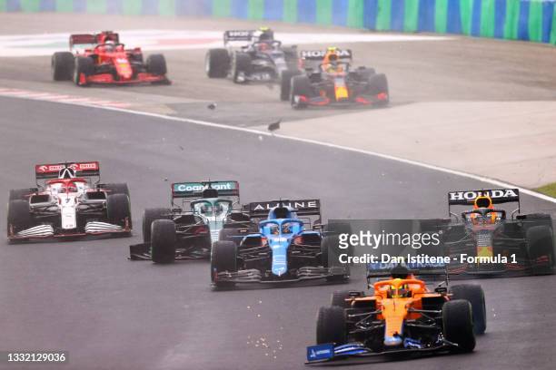 Fernando Alonso of Spain driving the Alpine A521 Renault next to, Max Verstappen of the Netherlands driving the Red Bull Racing RB16B Honda, Lando...