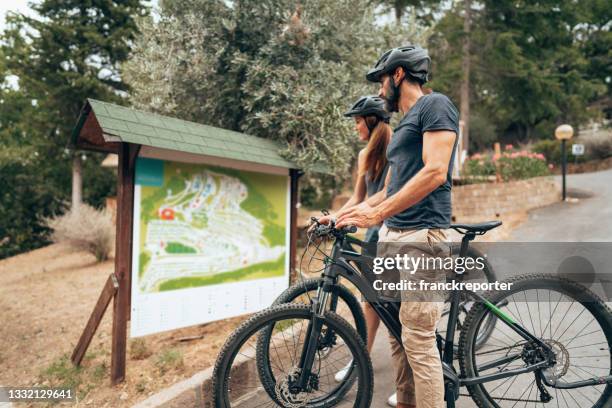 happiness couple with mountain ebike outdoors - roadmap stockfoto's en -beelden