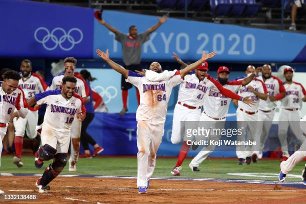Emilio Bonifacio and his teammates run onto the field to celebrate with Jose Bautista of Team Dominican Republic who hit a game-winning RBI single in...