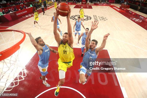 Dante Exum of Team Australia goes up for a dunk against Facundo Campazzo and Leandro Nicolas Bolmaro of Team Argentina during the second half of a...