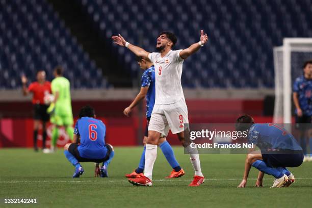 Rafa Mir of Team Spain celebrates their side's victory as the players of Team Japan look dejected after the Men's Football Semi-final match between...