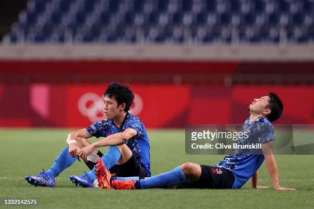 Wataru Endo and Maya Yoshida of Team Japan look dejected following defeat in the Men's Football Semi-final match between Japan and Spain on day...