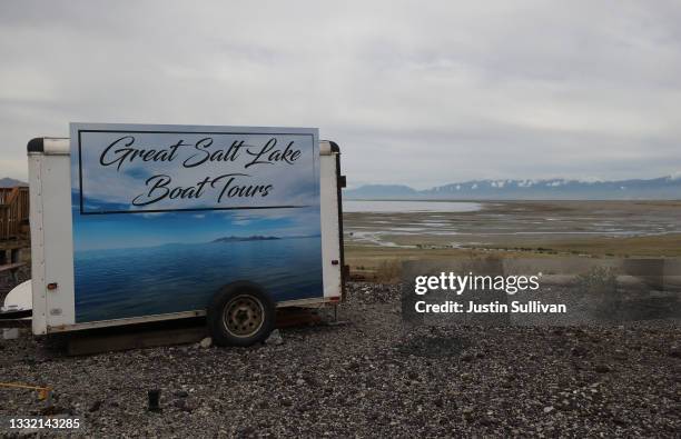 Sign advertising boat tours sits next to a section of the Great Salt Lake that used to be underwater at the Great Salt Lake State Park on August 02,...