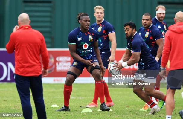 Maro Itoje of British & Irish Lions passes the ball to teammate Bundee Aki during a training session at Hermanus High School on August 03, 2021 in...