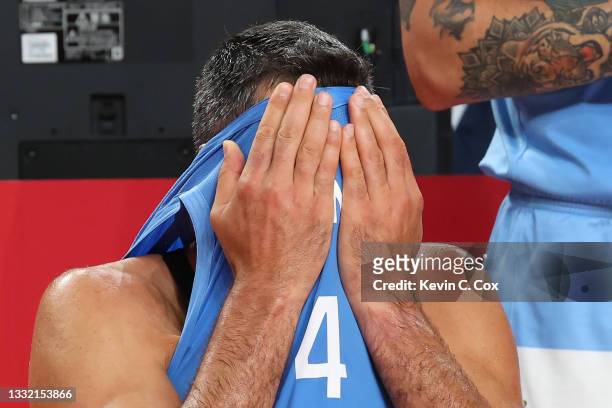 Luis Scola of Team Argentina covers his face with his jersey as he tears up with emotion following Argentina's loss to Australia in a Men's...