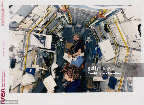 American NASA astronaut Bonnie J Dunbar with German DFVLR astronaut Reinhard Furrer in the background looking aft on Spacelab-D during Space Shuttle...