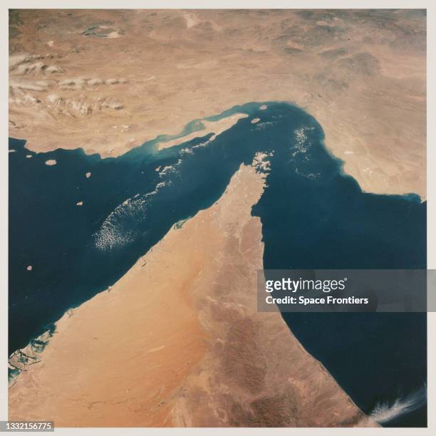 View looking north showing the Strait of Hormuz, connecting the Gulf of Oman with the Persian Gulf, with the Zagros Mountains and Qeshm Island of...