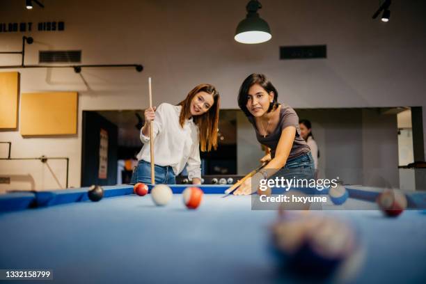 young woman office workers playing pool in the office - leaving work stockfoto's en -beelden