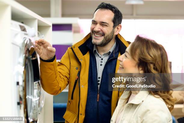 couple buying a washing machine - buying washing machine stock pictures, royalty-free photos & images