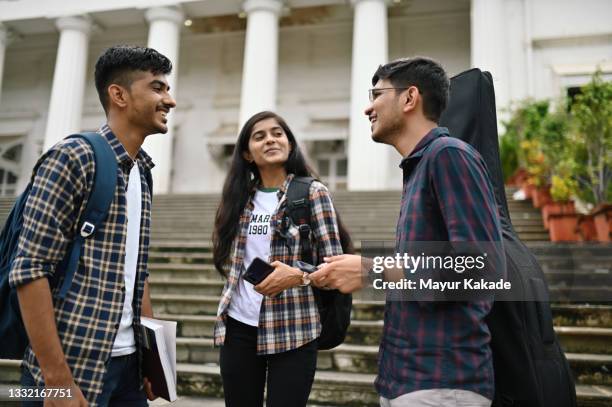 university student friends standing and talking in the university campus - indian student stock pictures, royalty-free photos & images