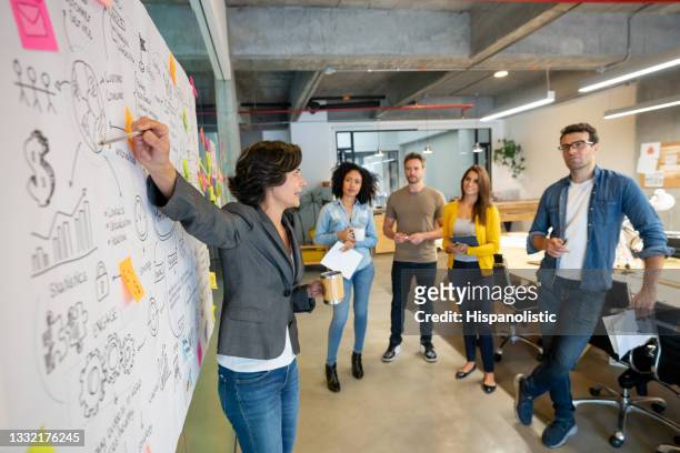 woman making a business presentation at a creative office - marketing stock pictures, royalty-free photos & images