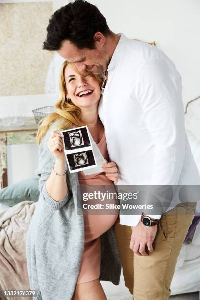 portrait of a happy pregnant adult woman with her husband - twin ultrasound stock pictures, royalty-free photos & images
