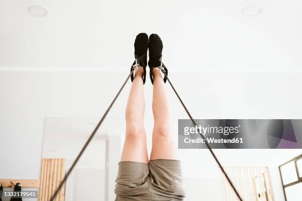 man doing leg-up while practicing pilates in studio - legs in stockings stock pictures, royalty-free photos & images