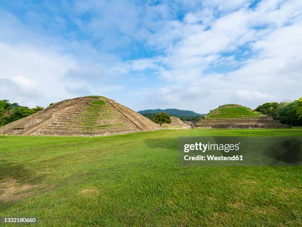 pyramids on grassy landscape at el tajin archaeological site, veracruz, mexico - pirâmide dos nichos imagens e fotografias de stock