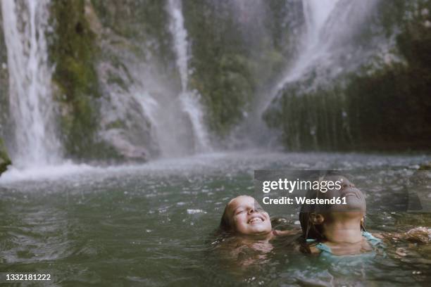 smiling girls with eyes closed having fun in water - river bathing imagens e fotografias de stock