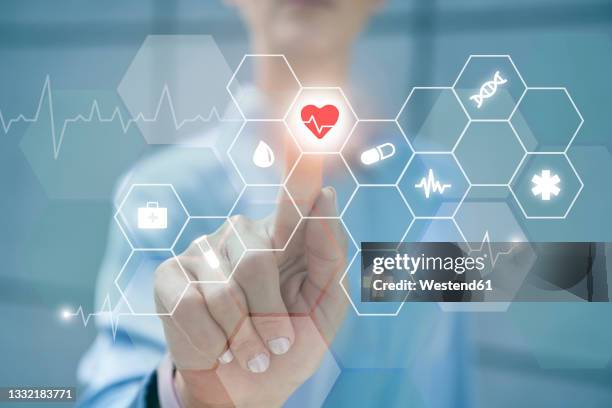 businesswoman touching heart shape on digital display - screening of at t audience networks mr mercedes arrivals stockfoto's en -beelden