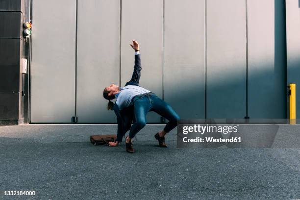 businessman bending over backwards on footpath - bending over backwards stock pictures, royalty-free photos & images