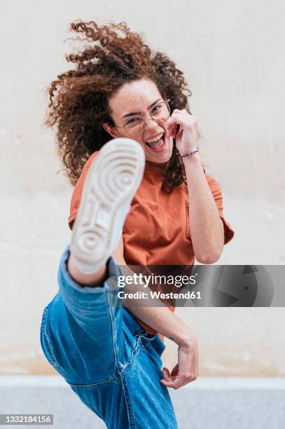 excited young woman kicking in front of wall - soles pose stock pictures, royalty-free photos & images