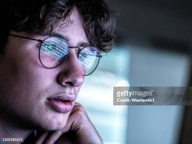 worried teenage boy with reflection on eyeglasses - identity theft stockfoto's en -beelden