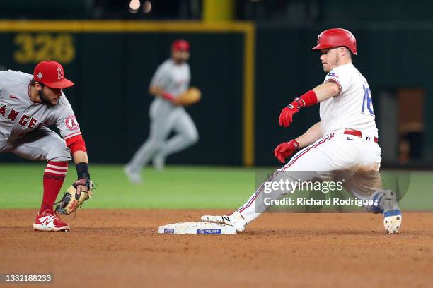 David Fletcher of the Los Angeles Angels is late with the tag as \Brock Holt of the Texas Rangers reaches second on a double at Globe Life Field on...