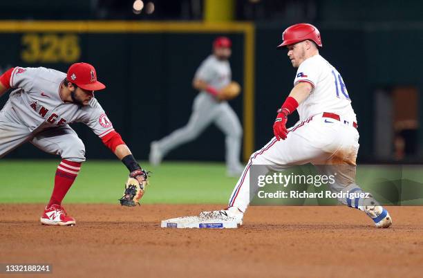 David Fletcher of the Los Angeles Angels is late with the tag as \Brock Holt of the Texas Rangers reaches second on a double at Globe Life Field on...