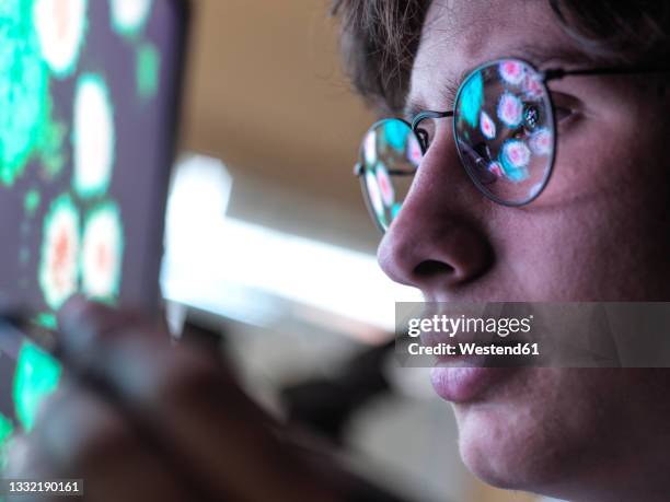 male expert examining coronavirus cells on computer monitor in laboratory - epidemiology research stock pictures, royalty-free photos & images