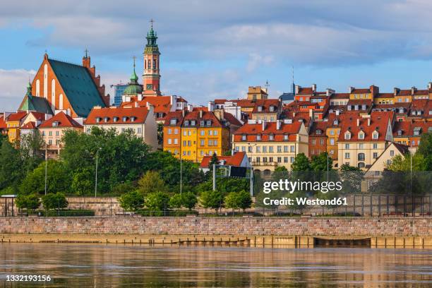 poland, masovian voivodeship, warsaw, bank of vistula river with old town buildings in background - warsaw stock-fotos und bilder