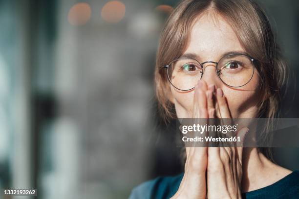 female professional wearing eyeglasses covering mouth with hands - sem palavras imagens e fotografias de stock