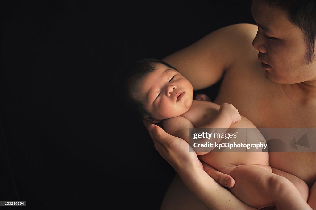 Father carry his baby with his arms