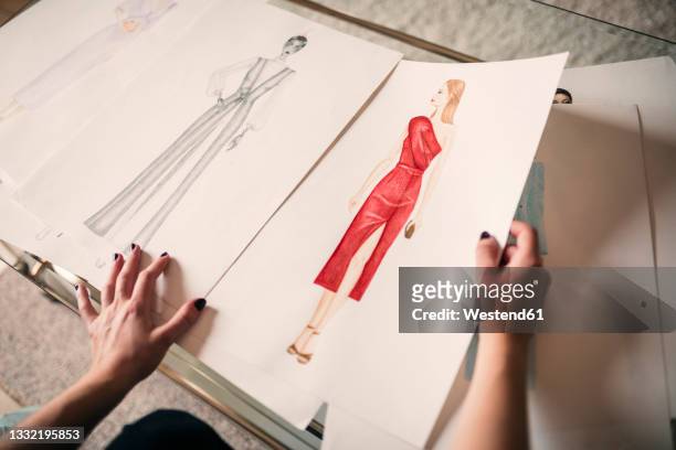 female design professional choosing sketch on table - modeontwerper stockfoto's en -beelden