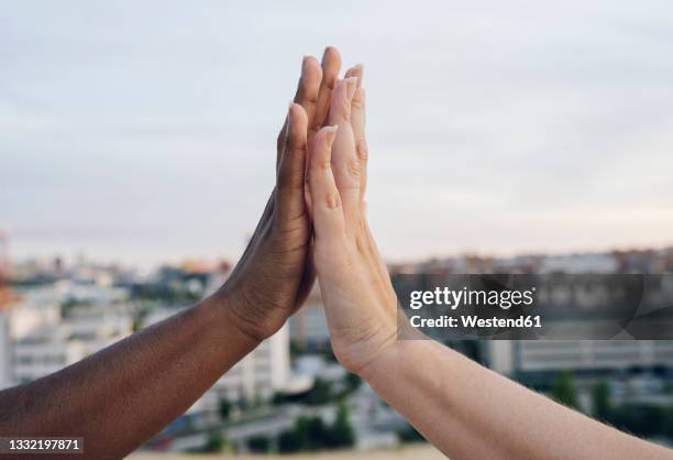 multi racial lesbian couple giving high-five - dammi un cinque foto e immagini stock