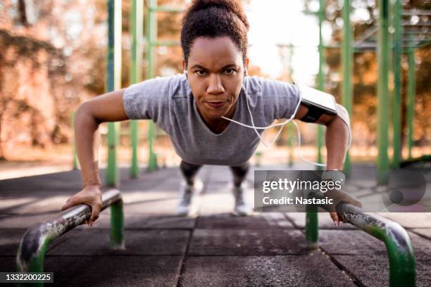 african american woman working out doing push ups - woman headphones sport smile iphone stock pictures, royalty-free photos & images