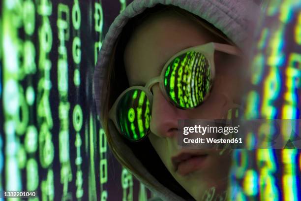female teenager with coding reflection on eyeglasses - anonymous hacker fotografías e imágenes de stock