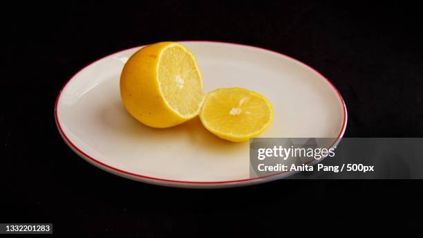 high angle view of lemon slices in plate on table - タイマツバナ ストックフォトと画像