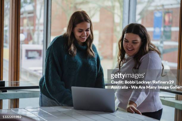 two smiling friends looking at a laptop together - native australian plants stock-fotos und bilder