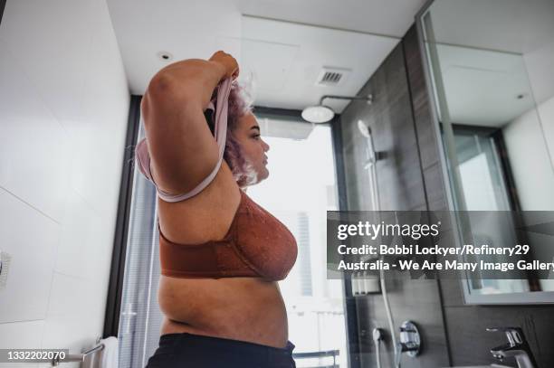 young woman getting changed - corpiño fotografías e imágenes de stock