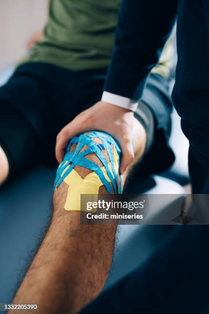 physiotherapie: patient mit kinesio tape auf kniesitzen bei medical ofiice - kinesiotape stock-fotos und bilder