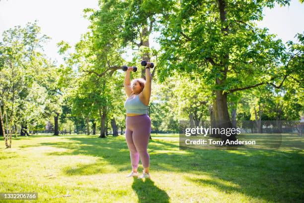 young woman working out with hand weights outdoors - hand weight - fotografias e filmes do acervo