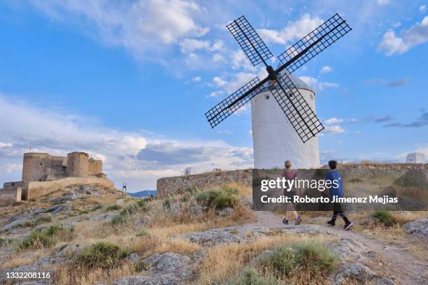 mother and son visiting the windmills and castle of consuegra, spain. - castilië la mancha stockfoto's en -beelden