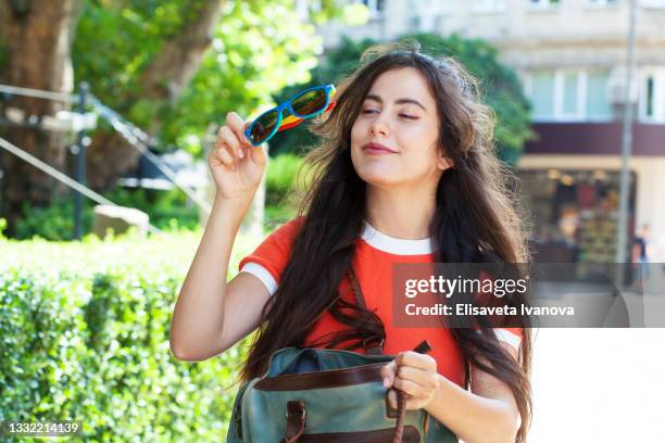 hermosa mujer que encuentra gafas de sol en su bolso - bolso abierto fotografías e imágenes de stock