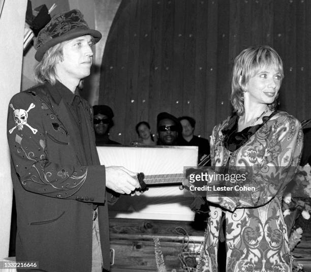 American singer, songwriter, musician, record producer, and actor Tom Petty and his wife Jane Benyo hold a knife to put in the casket as they attend...