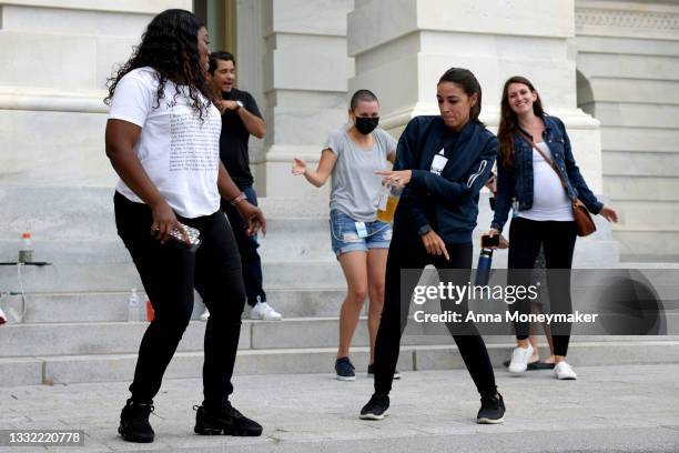 Rep. Cori Bush and Rep. Alexandria Ocasio-Cortez dance in celebration near the entrance to the Capitol Building on August 03, 2021 in Washington, DC....