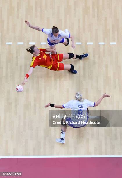 Tatjana Brnovic of Team Montenegro shoots at goal while falling down as Polina Gorshkova and Anna Sen of Team ROC defend during the Women's...