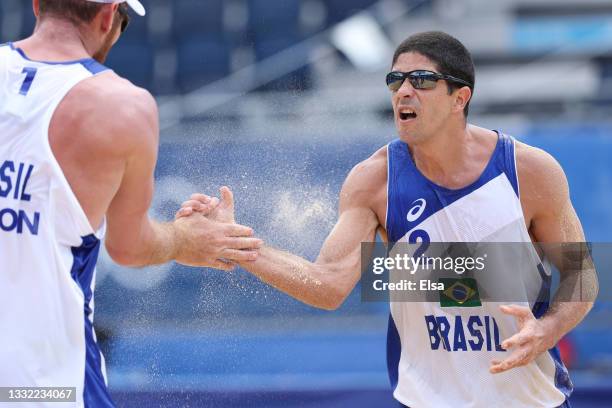 Alvaro Morais Filho of Team Brazil celebrates with Alison Cerutti against Team Latvia during the Men's Quarterfinal beach volleyball on day twelve of...