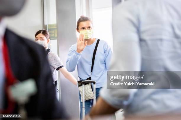 Belarus athlete Krystsina Tsimanouskaya waves at the boarding gate for Austrian Airlines 0S52 at Narita international airport on August 04, 2021 in...