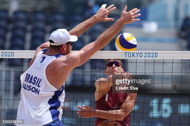 Alison Cerutti of Team Brazil defends against the strike by Martins Plavins of Team Latvia during the Men's Quarterfinal beach volleyball on day...